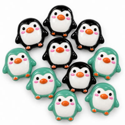 Ten tiny penguin flatback craft embellishments in black and mint green with white bellies, orange beaks and pink cheeks